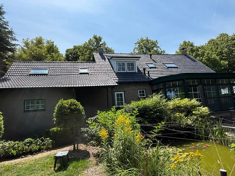 Gereinigd en gecoat dak van een woning met tuin